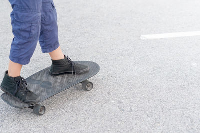 Low section of man skateboarding on road