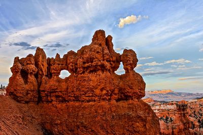 Rock formations against cloudy sky