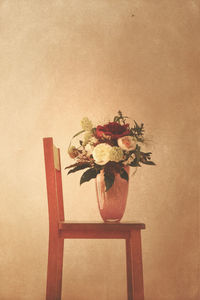 Close-up of flower vase on table against wall