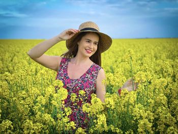 Beautiful young woman smiling while standing on field