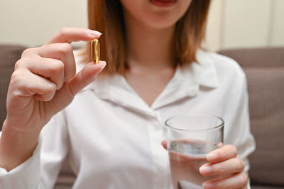 Midsection of woman holding drink