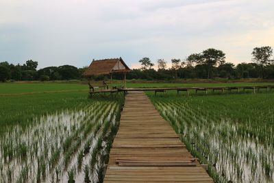 Wooden structure on field against sky