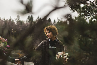 Lesbian couple with bouquets holding hands