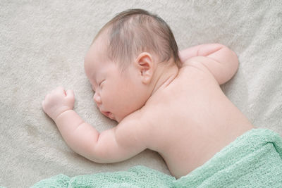 High angle view of baby sleeping on bed