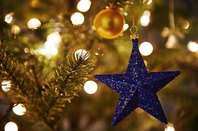 Close-up of blue star shape hanging from christmas tree