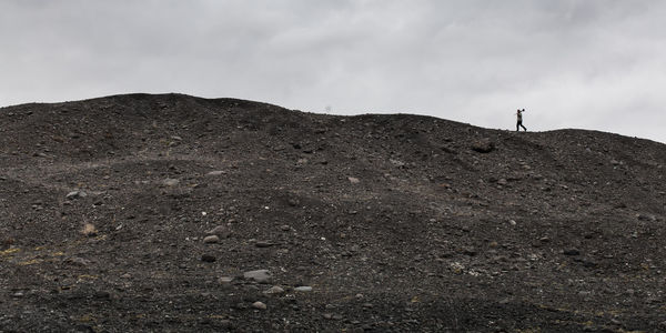 Low angle view of man on mountain against sky