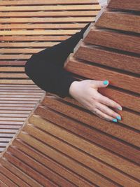 High angle view of woman hand on wooden table