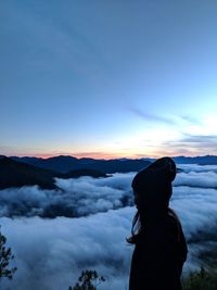 Silhouette woman standing on mountain against sky during sunset