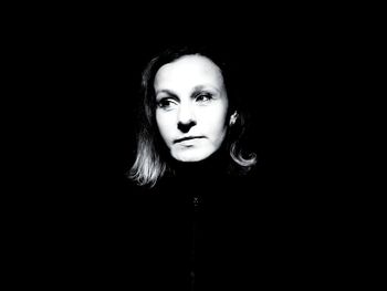 Portrait of beautiful young woman against black background