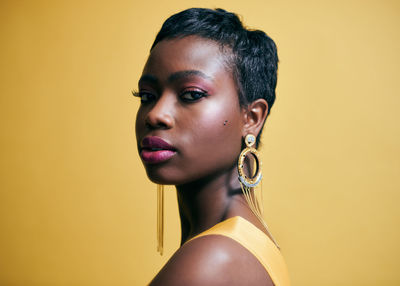 Portrait of woman against yellow background