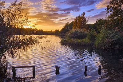 Scenic view of lake against sky at sunset