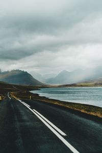 Road by lake against sky