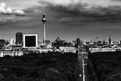 Buildings in city against cloudy sky