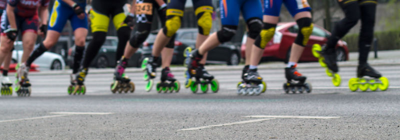 Low section of people inline skating on road