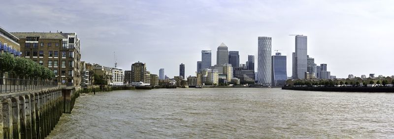 River amidst buildings in city against sky