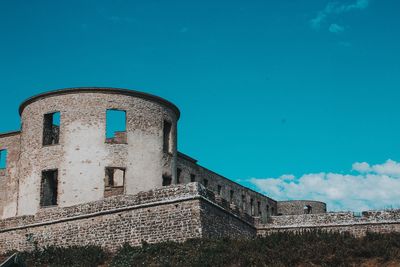 Low angle view of old ruins against blue sky