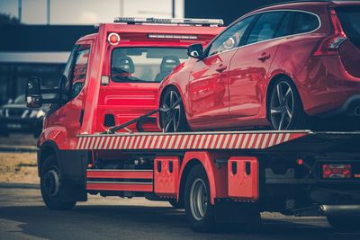 Red car on truck in city