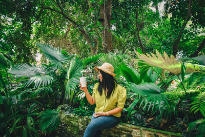 Woman wearing hat against trees