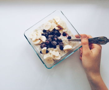Cropped image of person eating fruit salad