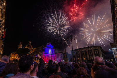 People watching firework display at night