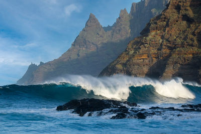 Scenic view of sea and mountains against sky