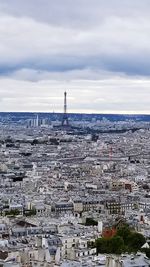 View of cityscape against cloudy sky