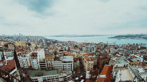 High angle view of cityscape by sea against sky