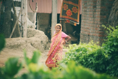 Portrait of young woman standing on field