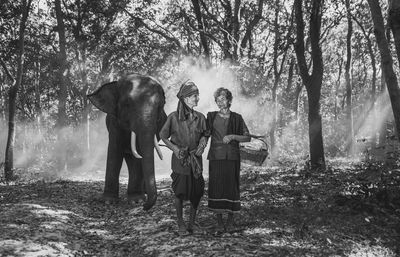 Senior couple with elephant in background at forest