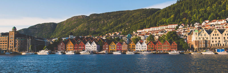 Sailboats in sea against buildings in city