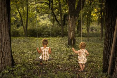 Full length of children playing in forest