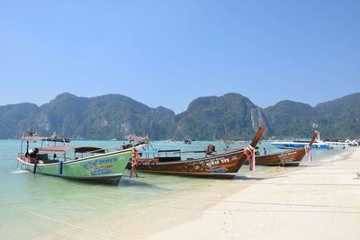 Boats moored on sea against clear sky