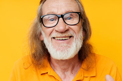 Portrait of young woman against yellow background