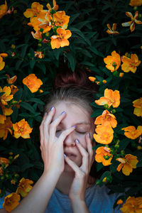 Low angle view of human hand on flowering plants