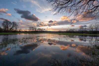 Scenic view of lake against sky at sunset