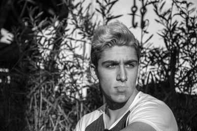 Portrait of young man against trees