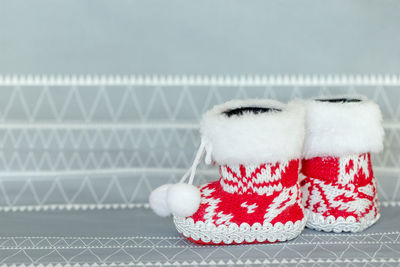 Cute little christmas knitted red shoes, socks, boots with an ornament, decoration toy