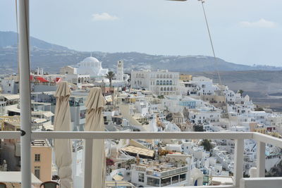 Buildings in city by sea against sky