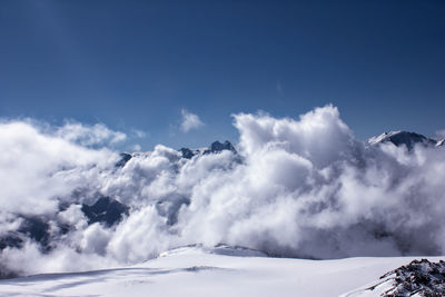 Scenic view of snow mountains against blue sky