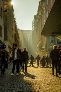 Rear view of people walking on street in city