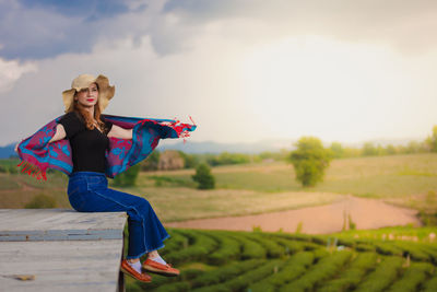Woman with arms raised on field against sky in the choui fong tea plantation  thailand