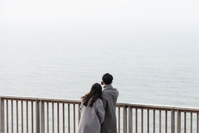 Rear view of woman looking at sea against sky