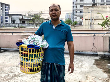 In the following image, neighbour hand wash clothes dry up hang on a drying line at rooftop of house 