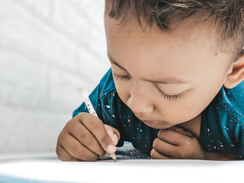 Close-up portrait of boy holding table