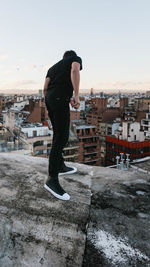 Full length of man standing by building against sky