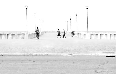 People on beach against clear sky