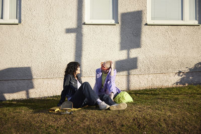 Smiling female friends or gay couple relaxing together at spring