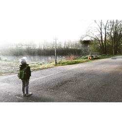 Rear view of woman walking on road