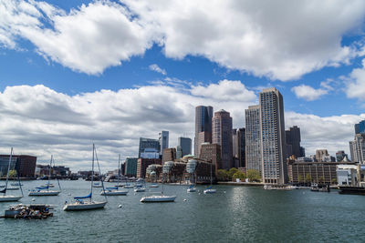 City at waterfront against cloudy sky