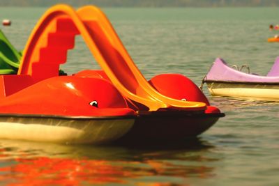 Close-up of red boat moored in lake